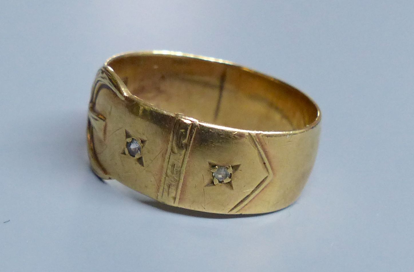 A modern 9ct gold and two white stone chip set buckle ring, size U/V, gross 5.1 grams.